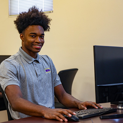 Male student sitting in the computer lab.