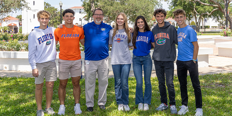 Senior students with an Upper School teacher wearing their University of Florida shirts.