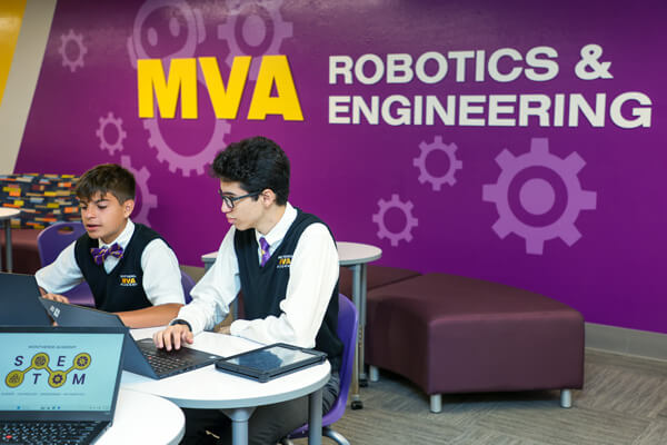 Students sitting at computers in the Robotics and Engineerring space.